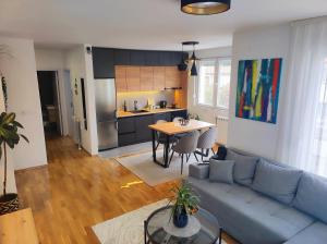 a living room with a blue couch and a kitchen at Riverside LUX Apartment in Pirot