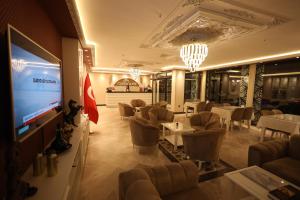 un ristorante con tavoli e sedie e un grande schermo di Green Roof Boutique Hotel & SPA Istanbul Airport a Terkos