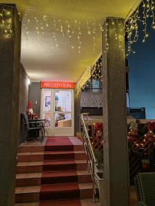 eine Treppe, die zu einem Geschäft mit einem roten Schild führt in der Unterkunft Bed and Breakfast Majesty in Niš