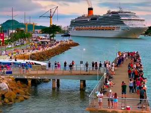 a cruise ship parked next to a pier with a crowd of people at cantinho jardim in Santos