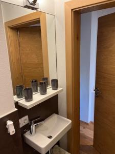 ein Bad mit einem Waschbecken und einem Spiegel in der Unterkunft Central Hideaway in Maria Alm am Steinernen Meer