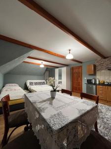 a room with a table and a bed and a kitchen at Pokoje u Pawloka - BLISKO TERMY CHOCHOŁOWSKIE in Ciche