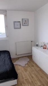 a white bedroom with a bed and a window at Appartement proche aéroport Beauvais-tille in Beauvais