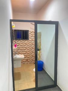 a bathroom with a glass door and a sink at Charly-chic@ in Cotonou