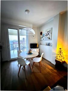 a living room with a dining room table and chairs at Attico Gabri - Appartamento con terrazzo panoramico vicino al Centro in Turin