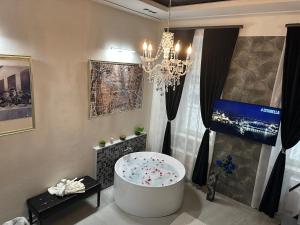 a bathroom with a bath tub and a chandelier at Legendary Apartment in Budapest