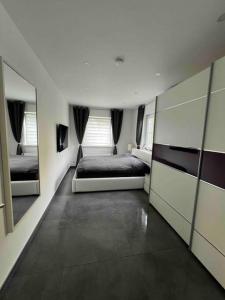 1 dormitorio con cama y espejo grande en Schönes 2 Zimmer Apartment an der Stadt Grenze en Blankenfelde