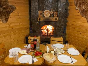 a table with plates of food and a fireplace at Guсulka Ksenia in Kosiv