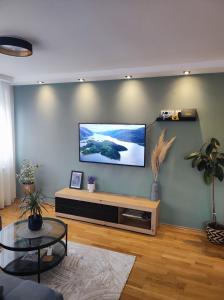 a living room with a flat screen tv on a wall at Riverside LUX Apartment in Pirot
