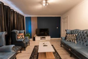 a living room with blue furniture and a tv at Abdon house in Birmingham