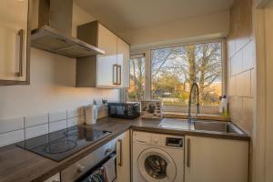 a kitchen with a sink and a washing machine at Abdon house in Birmingham