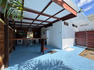 um pátio com um telhado com uma mesa e uma secretária em Meri Lodge Huahine XXThe Bee HouseXX em Fare