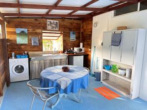 a kitchen with a table and a washing machine at Meri Lodge Huahine XXThe Bee HouseXX in Fare