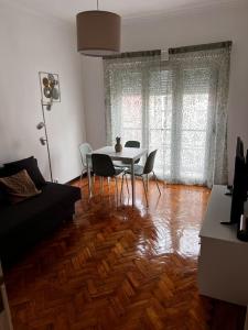sala de estar con mesa, sillas y sofá en Guiki House en Lisboa