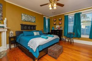 een slaapkamer met een bed met blauwe lakens en gele muren bij The Bagley House: built in 1911 in Blackstone