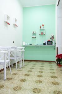 une salle à manger avec des tables et des chaises blanches dans l'établissement TreCuori, à Naples