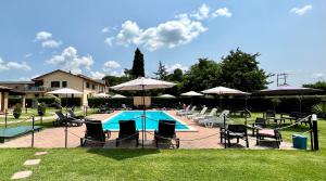 a swimming pool with chairs and umbrellas in a yard at Oasi di Agilla in Panicarola +31 photos