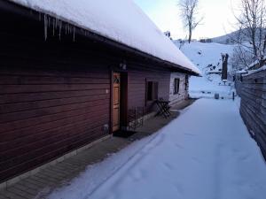 Una cabaña con nieve en el costado. en Domček KaMi en Kráľová Lehota