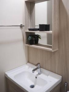 a bathroom with a white sink and a mirror at Youth City Cozy Pool View Homestay Nilai by TR in Nilai