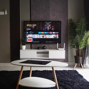 a living room with a tv and a white table at Youth City Cozy Pool View Homestay Nilai by TR in Nilai