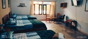 sypialnia z 2 łóżkami i oknem w obiekcie Poseidon Guest House w mieście Iquitos