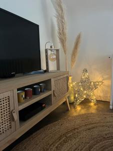una sala de estar con TV y una estrella de Navidad en Le 6 appartement Caen Port & Abbaye-aux-Dames en Caen