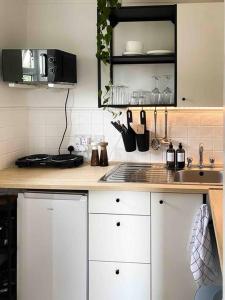 uma cozinha com armários brancos e uma bancada em Cozy studio near train station em Cambridge