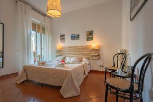 1 dormitorio con 1 cama con mesa y sillas en La casa di Lucca - terrace and parking, en Lucca