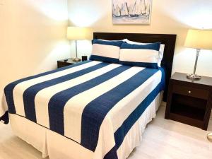 um quarto com uma cama listrada em azul e branco com 2 candeeiros em Peaceful Paradise em Tampa