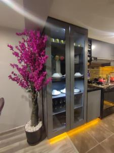 a vase with purple flowers in front of a kitchen at departamento independiente in Puno