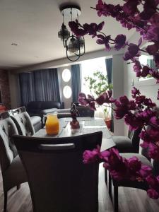 a room with a table with an orange juice and flowers at departamento independiente in Puno