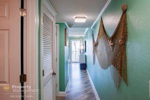 a hallway with green and blue walls and wooden floors at Rays by the Bay in Tampa
