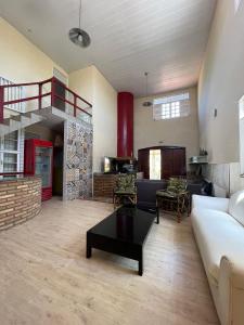 a living room with a couch and a table at Pousada Sapê in Praia do Frances