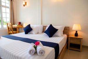 a bedroom with two beds with towels and a table at Biosphere Inn in Dharavandhoo
