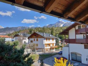 een uitzicht vanaf het balkon van een huis met bergen bij Appartamento comodo e curato per famiglie in Pieve di Cadore