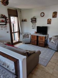 uma sala de estar com um sofá e uma televisão em Appartamento comodo e curato per famiglie em Pieve di Cadore