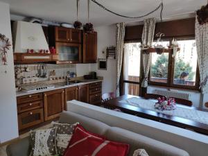 a living room with a couch and a kitchen at Appartamento comodo e curato per famiglie in Pieve di Cadore