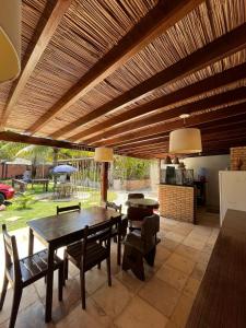 a dining room with a table and chairs under a wooden ceiling at Pousada Sapê in Praia do Frances