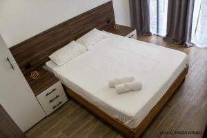 Villa El Bosque Dorado في فورتونا: غرفة نوم عليها سرير وفوط بيضاء