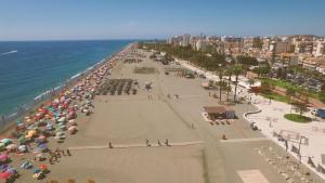 plaża z mnóstwem parasoli i oceanu w obiekcie Centro-Torre del mar - HOME RENT MALAGA w mieście Torre del Mar