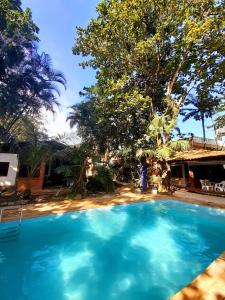 a large blue swimming pool in front of a house at Pousada e SPA Canto do Mar in Guarujá