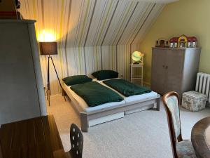 a bedroom with a bed with green pillows at Wellness Oase auf dem Land in Buttstädt