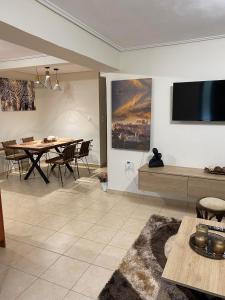 a living room with a table and a tv on the wall at Garden View Apartment in Athens