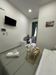 a room with a bed and a table with a tv at Garibaldi guest house in Naples