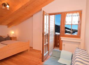 a bedroom with a bed and a large window at Housetirol in Valdaora di Sotto