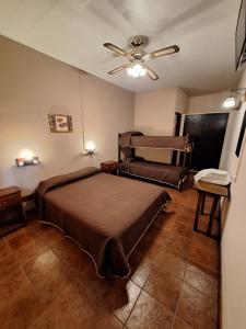 1 dormitorio con 1 cama y ventilador de techo en Hotel Vireo en Villa Gesell