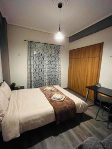 a bedroom with a bed and a table and a desk at Billy's cozy place Trikala in Tríkala