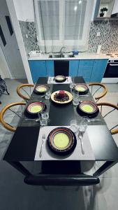 a table with plates and wine glasses on it at Billy's cozy place Trikala in Tríkala