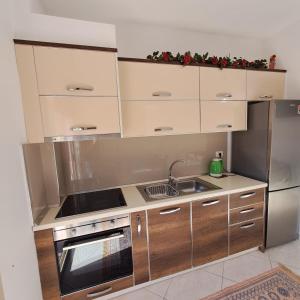 a kitchen with a sink and a stove top oven at Flowers & Green 2 Bedrooms Apartment & Private garage in Vlorë