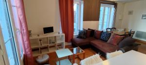 sala de estar con sofá y mesa en Double gite, Duplex et Chaleureuse petite maison, en Beaumont-sur-Sarthe
